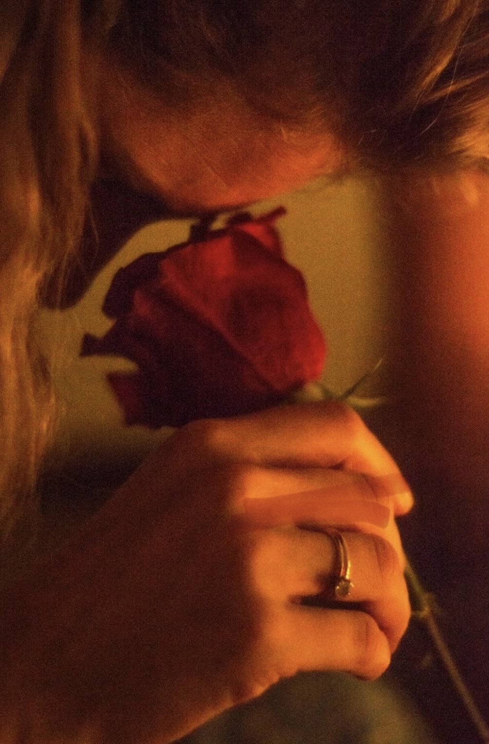 Rose rouge près du visage, symbole du désir féminin et de l’intimité